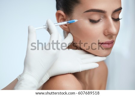 Cosmetic Treatment. Closeup Beautician Hands Doing Facial Skin Lifting Injection To Woman\'s Face. Beautiful Female With Closed Eyes Receiving Beauty Procedure Indoors. Plastic Surgery. High Resolution