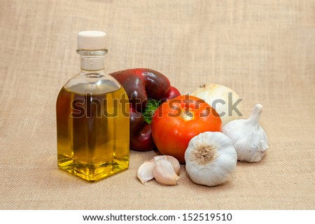 vegetable still life with bottle of oil isolated on rustic background