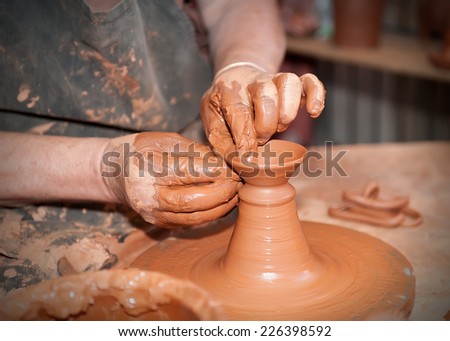potter working on the lathe with a lump of clay