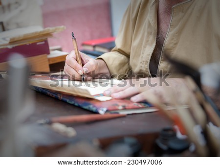 court clerk with pen in hand writing on parchment