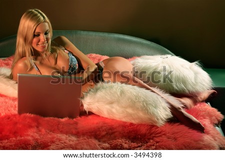 stock photo Undressed girl on the bed with notebook looking exited in it