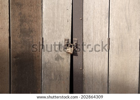 the old wooden door and padlock with the sun light and shadow in afternoon.