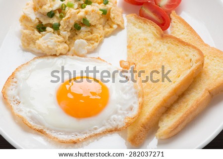 fresh fried egg and scrambled egg with bread for breakfast