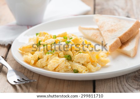 The breakfast with scrambled egg, toasts and coffee.