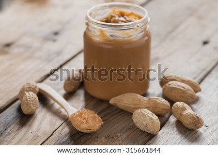 Creamy peanut butter on wood table. Selective focus.