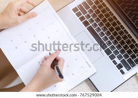 Businesswoman planning agenda and schedule using calendar event planner. Woman hands writing plan for working and schedule this month. Planner of meeting plan job.