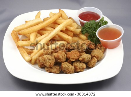 chicken and fries with tomato ketchup in a plate