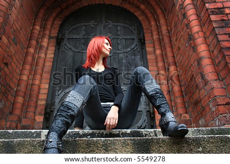 girl with red hair is sitting on the stairs (boots in focus)