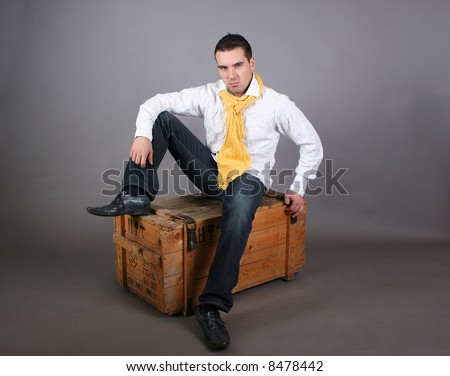 modern young guy sitting on the wooden box