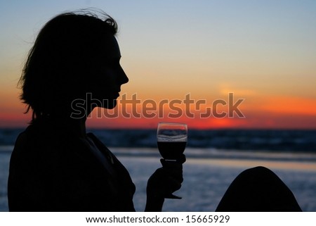 young girl drinking wine on the beach