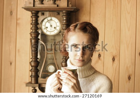 cute young girl drinking tea in cottage