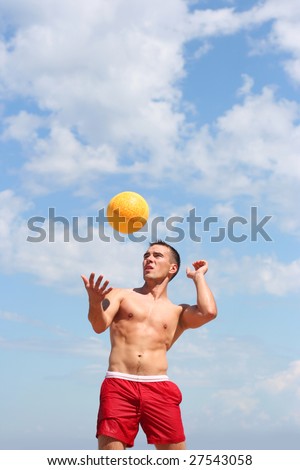 athletic guy playing volley-ball on the beach