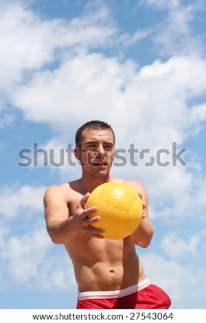 athletic guy playing volley-ball on the beach