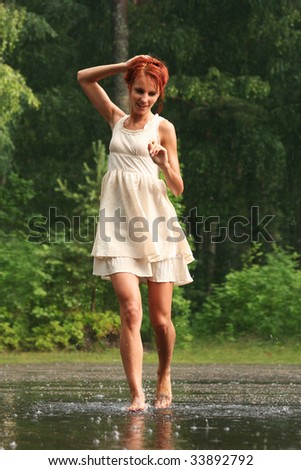 happy young woman walking in the rain