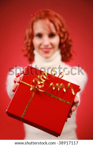 funny redhead woman with bright red present (box in focus)