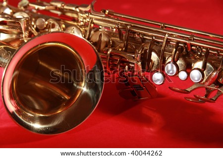 golden shiny saxophone on red background