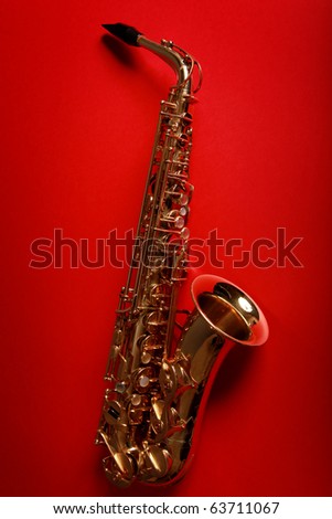 golden shiny saxophone on red background