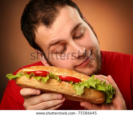 funny guy eating hamburger on red background