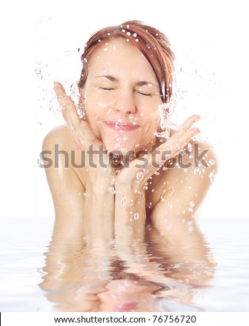 young woman washing her face with water