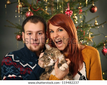 funny young couple and christmas tree
