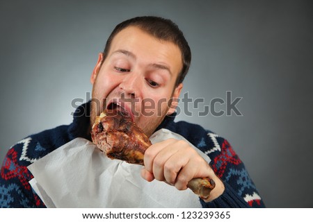 happy young man eating meat
