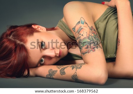 Young tattooed girl on dark background
