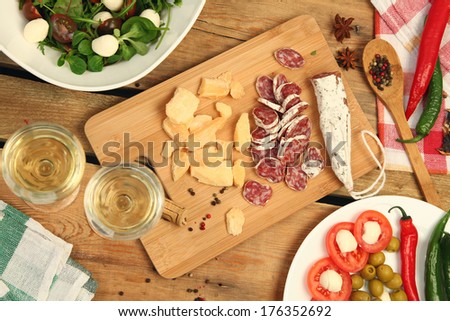 white wine and different snacks on wooden table