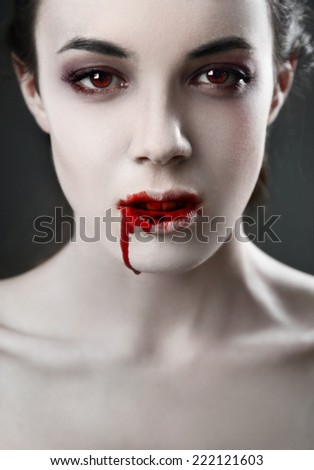 Portrait of a female vampire over black background