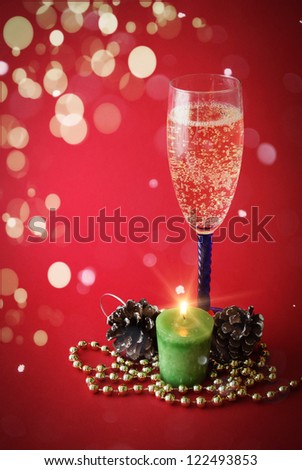 Glass of wine with candle and  Christmas decor in the background