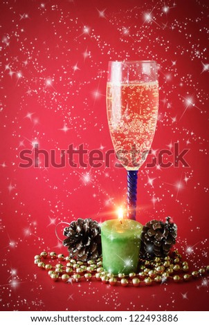 Glass of wine with candle and  Christmas decor in the background