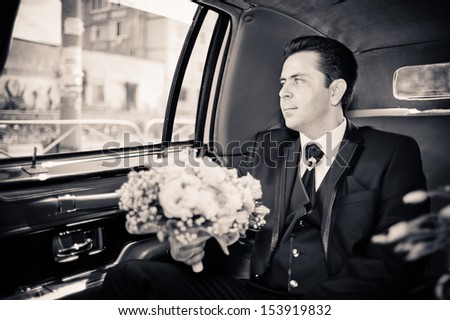 groom in limousine with wedding bouquet