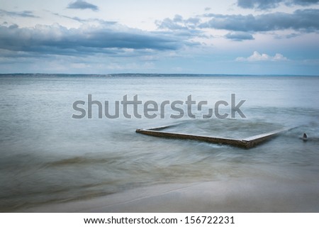 Seascape. The composition of nature. Concrete slab in the water.