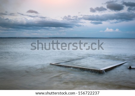 Seascape. The composition of nature. Concrete slab in the water.