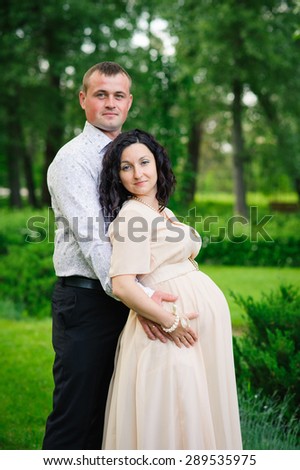 Happy family. A pregnant woman with her husband at the park.