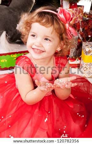Girl enjoys the snow and catch it with his hands, a Christmas tree, studio photography