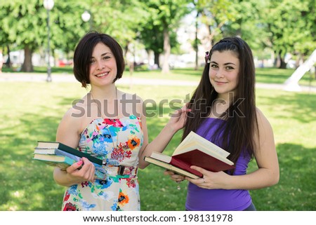 Two girls students studying subjects in the park