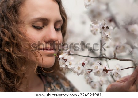 Sensual portrait of a spring woman, beautiful face, female enjoying cherry blossom, dreamy girl with pink fresh flowers outdoor, seasonal nature, tree branch and natural beauty