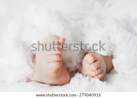 Newborn baby feet are wearing a lace skirt/Newborn baby feet/Newborn baby feet