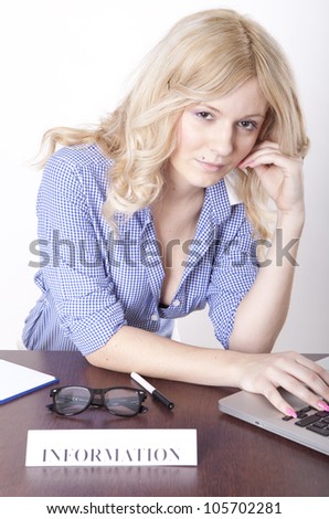 Portrait of a young attractive secretary working at the information desk.