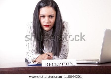 Portrait of a young attractive female receptionist working at information desk.