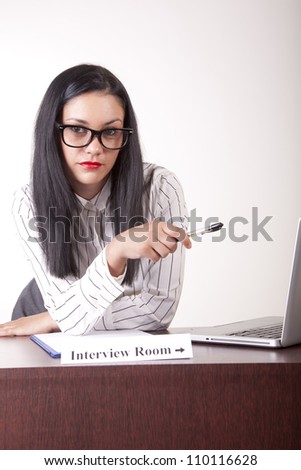 Portrait of a young attractive female secretary with a sign interview room.