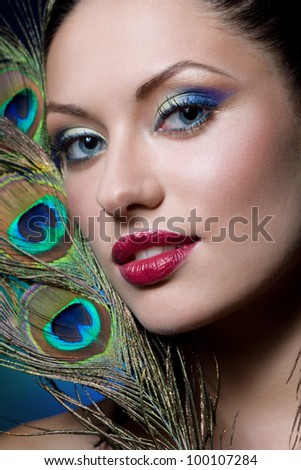 young gorgeous brunette with peacock style makeup, studio shot