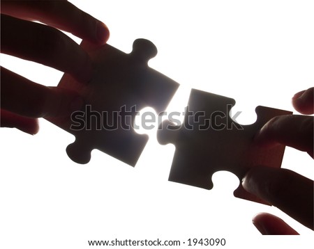 hands trying to fit puzzle