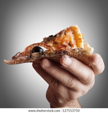 Hand holding cut off slice pizza High resolution