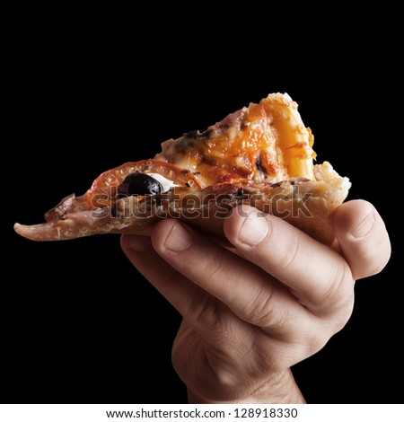 Hand holding cut off slice pizza isolated on black background High resolution