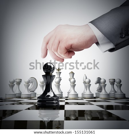 Strategy concept. hand holding black chess figure on chess board