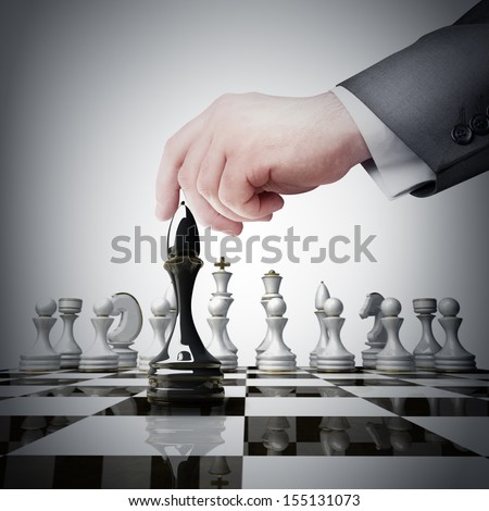 Strategy concept. hand holding black chess figure on chess board