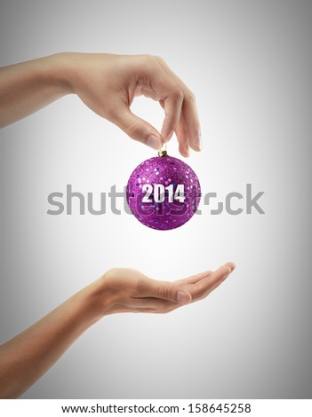 male hands give a christmas ball 2014 High resolution