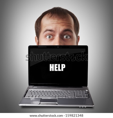 Young man disappearing behind a laptop