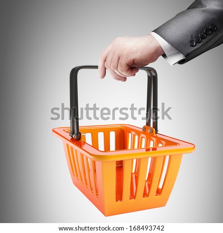 hand holding object ( orange plastic shopping basket ) High resolution